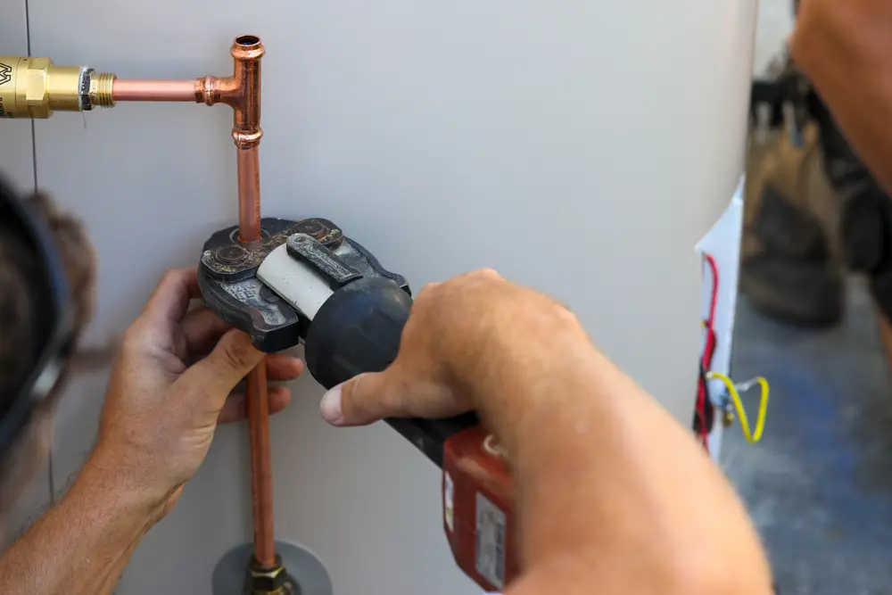 close up of a plumber installing an electrical hot water heater