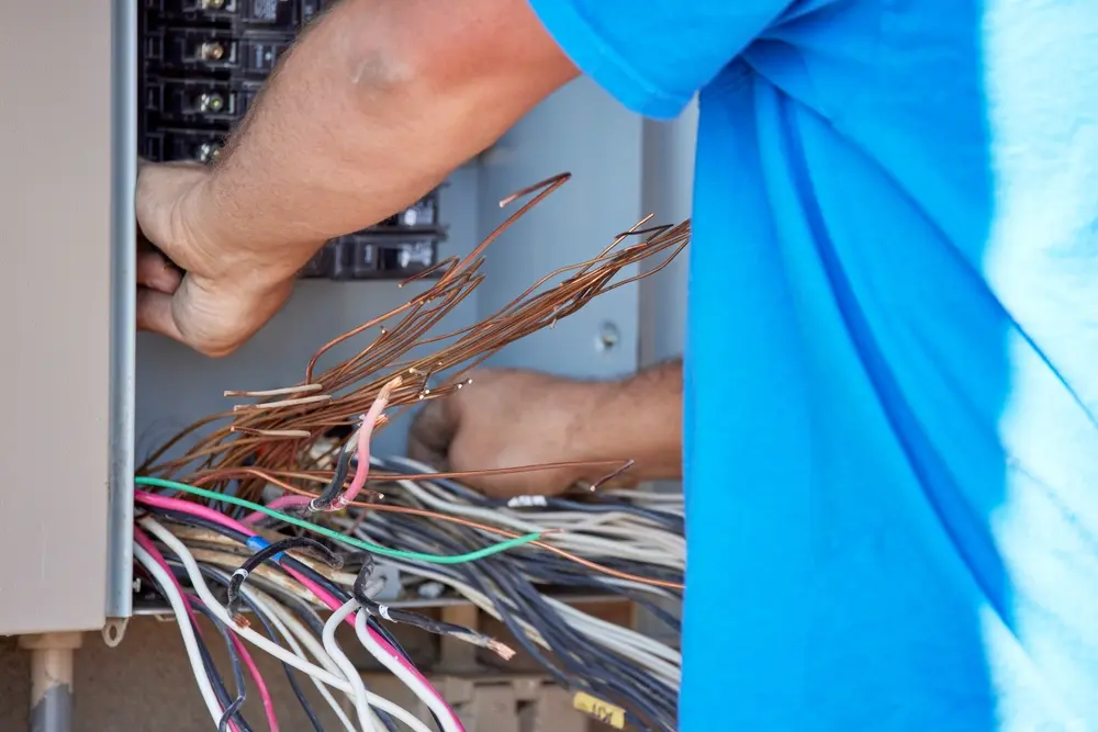 electrician installing a transfer panel for a whole-house generator