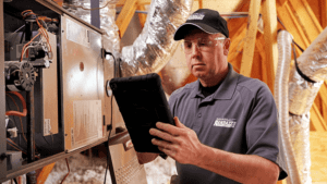 A Randazzo technician installing a furnace and inspecting it.