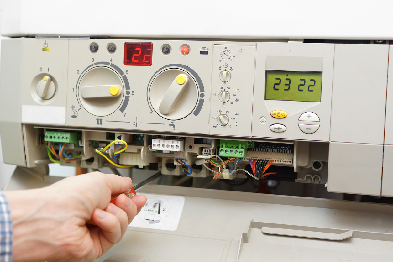 HVAC technician fixing a furnace in a Michigan home