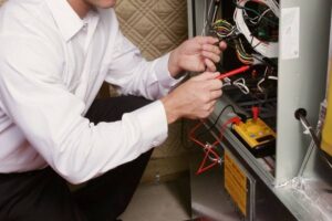 HVAC Tech performing maintenance on a furnace