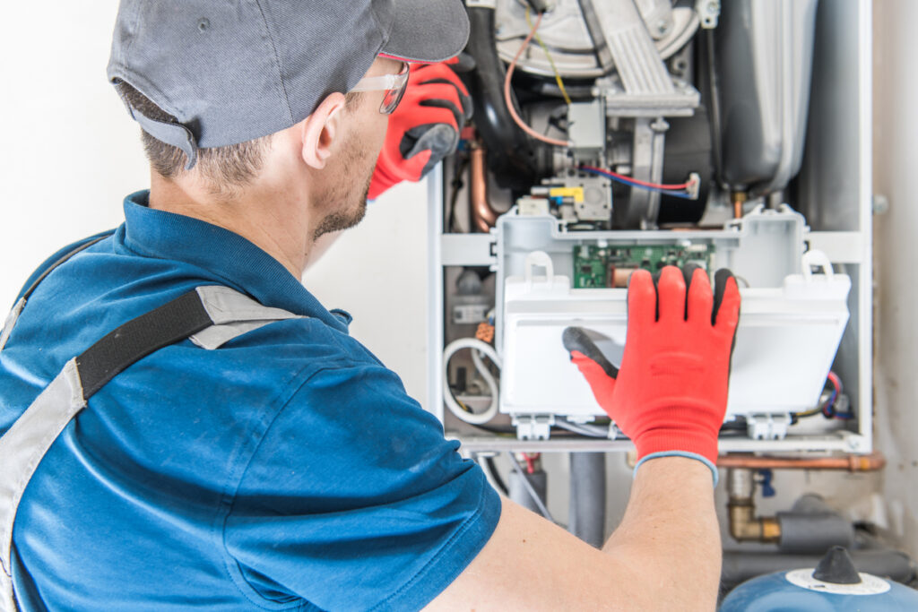 HVAC technician performing repair on a residential furnace