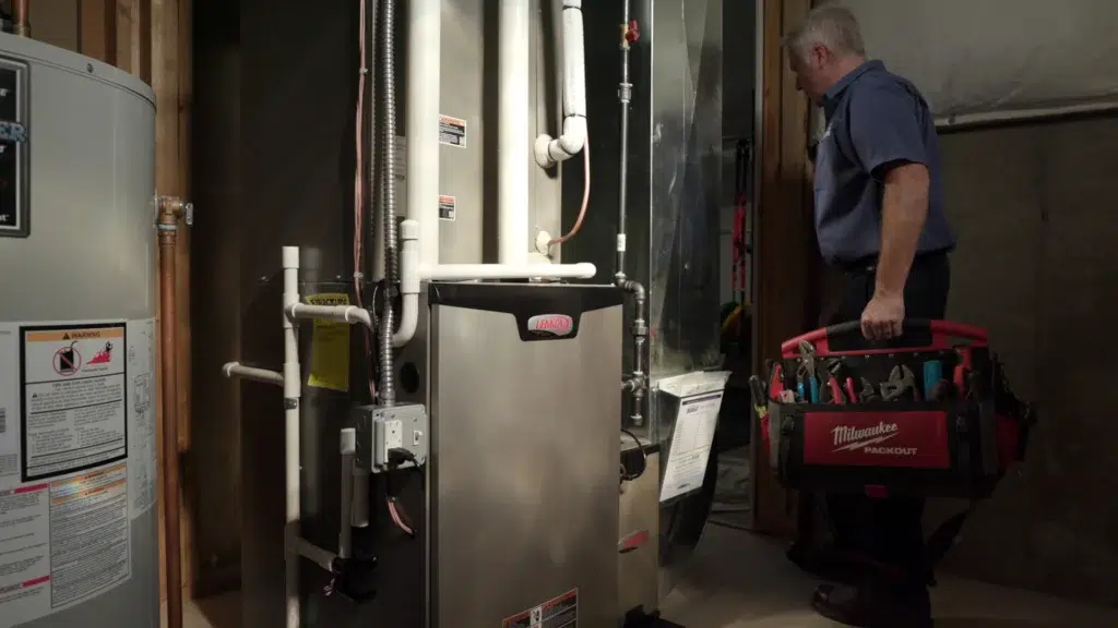 A Randazzo employee looking at a furnace with his toolbox