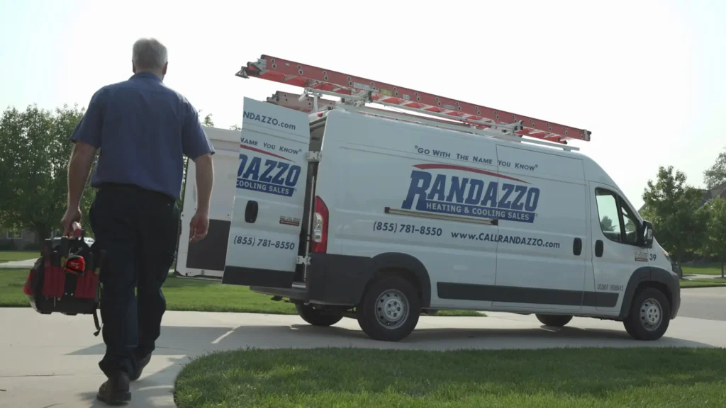 a man walking towards a van that says randazzo heating and cooling sales